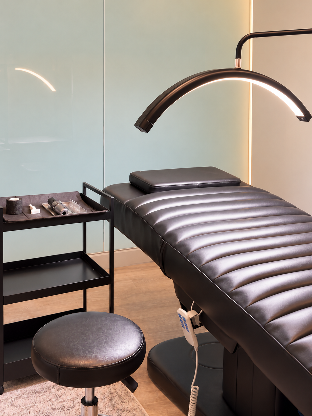 Inside Julvenation: black treatment bed, curved light, and treatment trolley